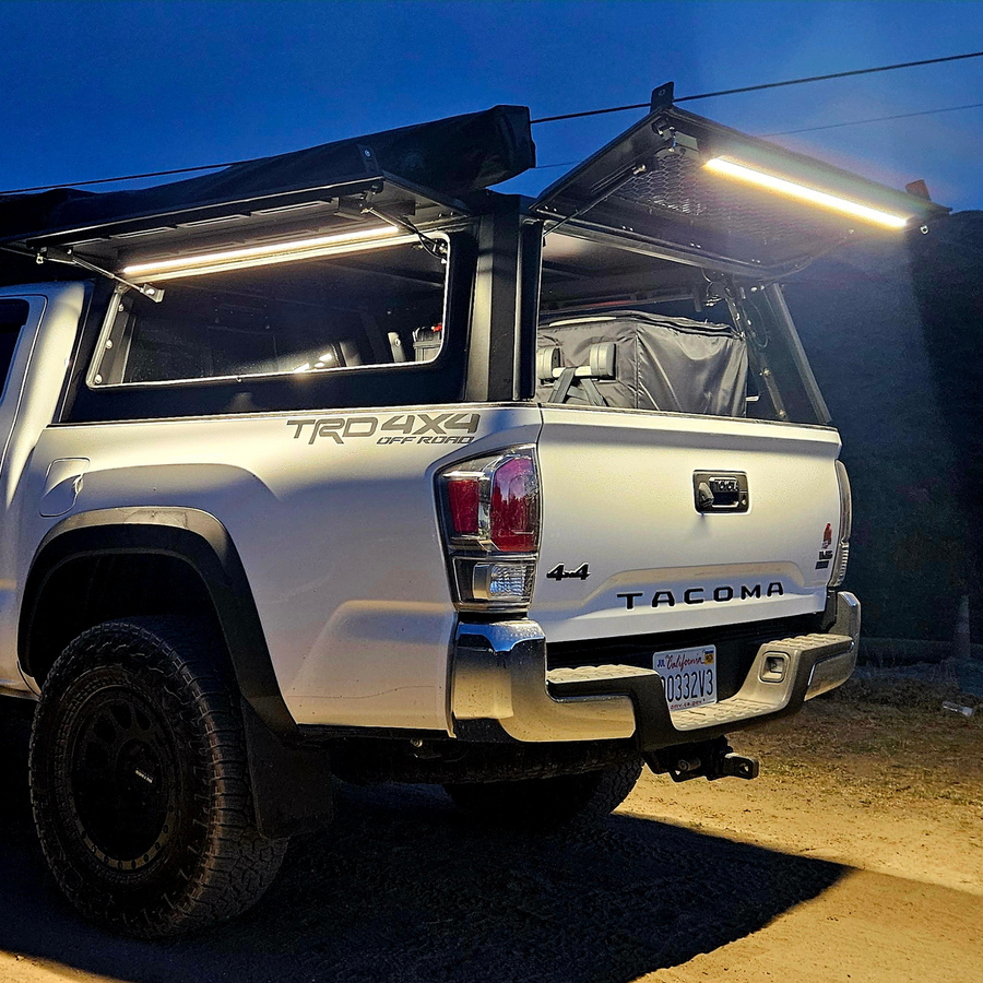Pickup with a truck cap at dusk, lit by Kingpin lights inside the cap