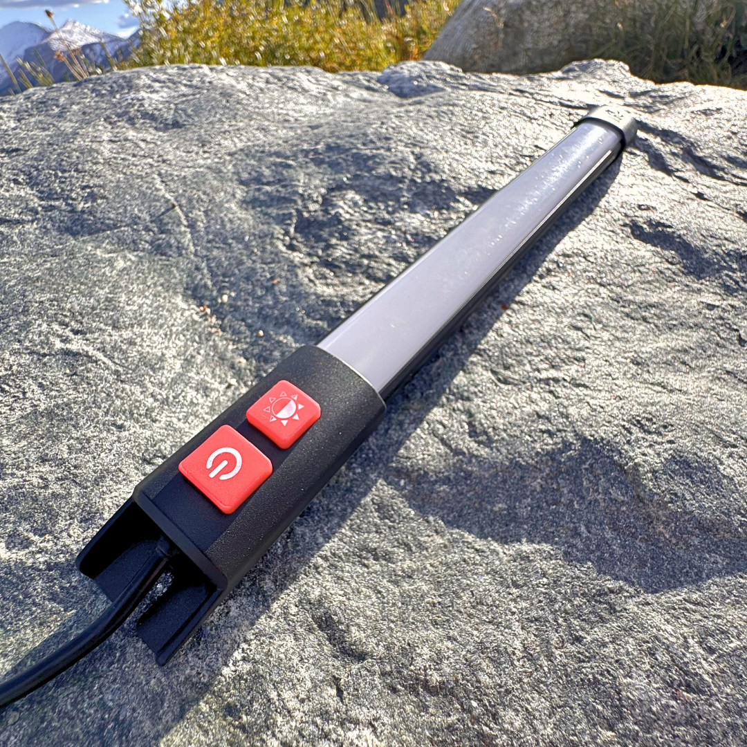 Kingpin F-Series light with its buttons, resting on a rock