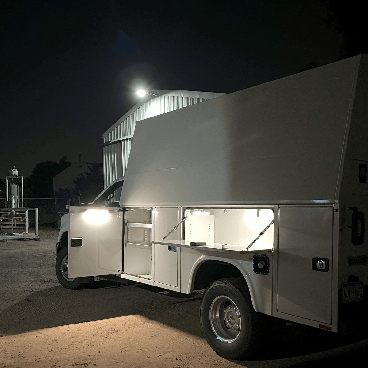 Utility work truck at night with side compartments lit by Kingpin lights