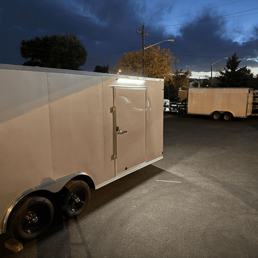 White enclosed trailer at dusk with a Kingpin light over the side door