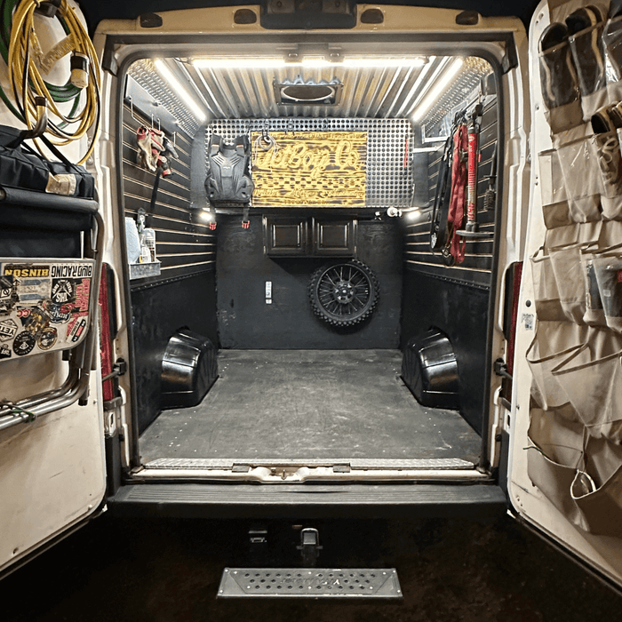 Open cargo van with motorcycle gear, lit by Kingpin lights on the ceiling
