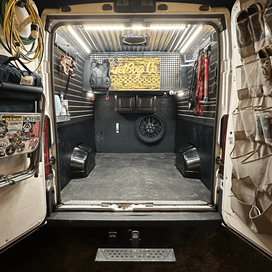 Open cargo van with motorcycle gear, lit by Kingpin lights on the ceiling