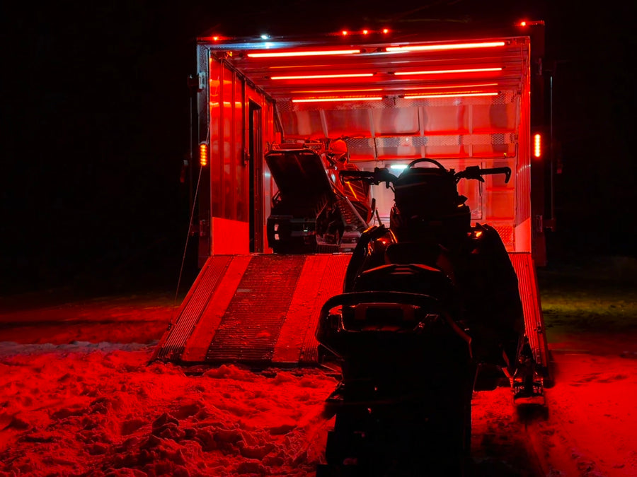 Enclosed trailer at night with dirt bikes, lit red by Kingpin F-Series lights