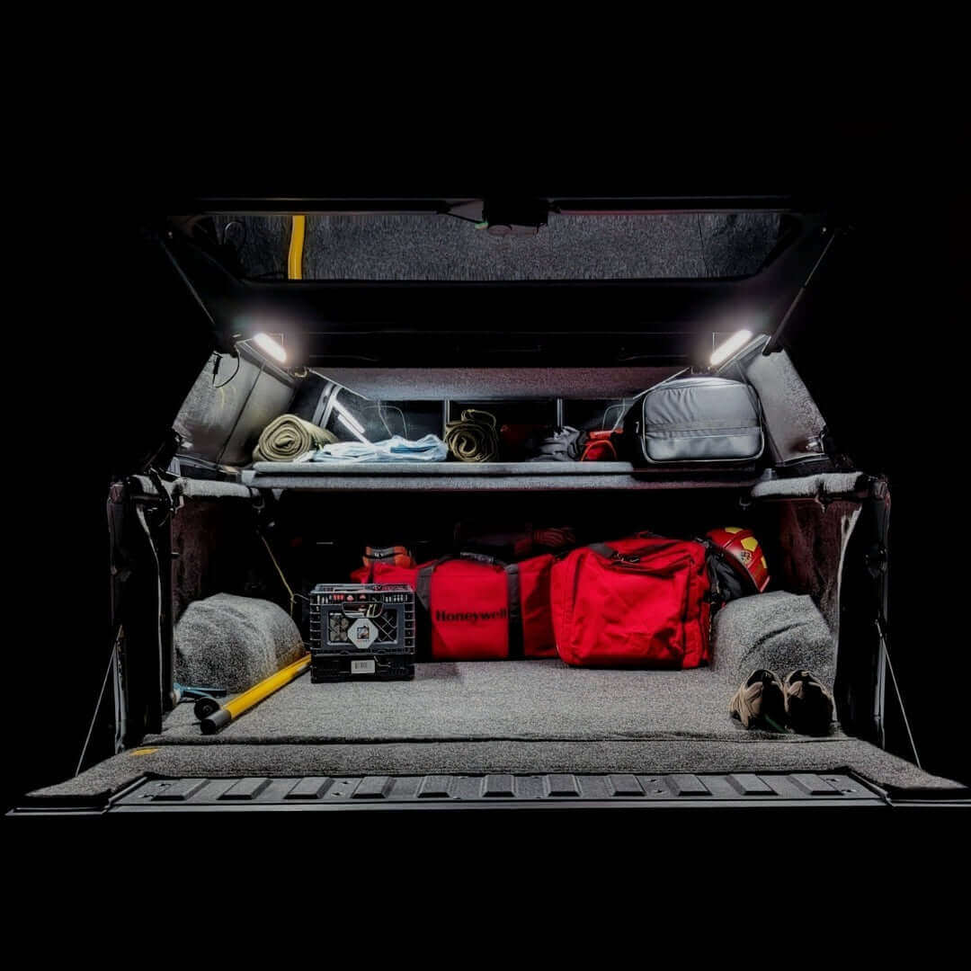 Truck cap packed with camping gear at night, lit by Kingpin lights