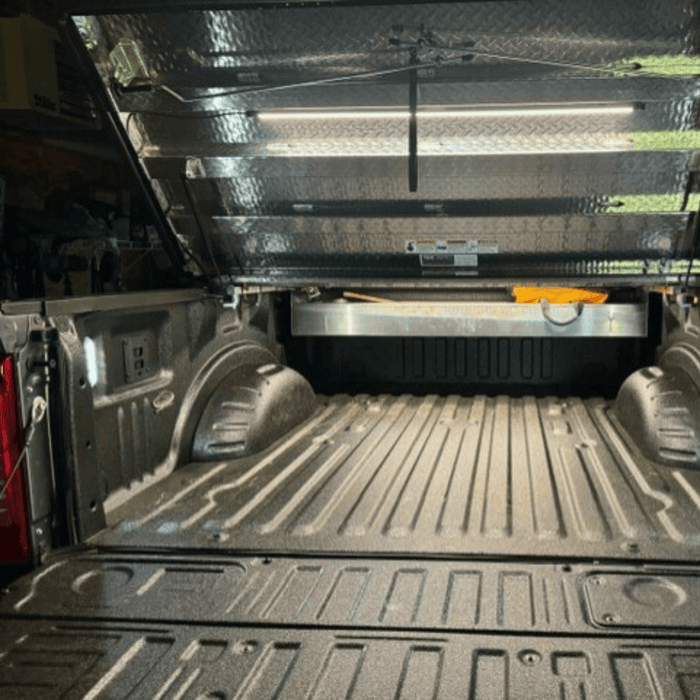 Truck bed under a bed cover lit by a Kingpin light