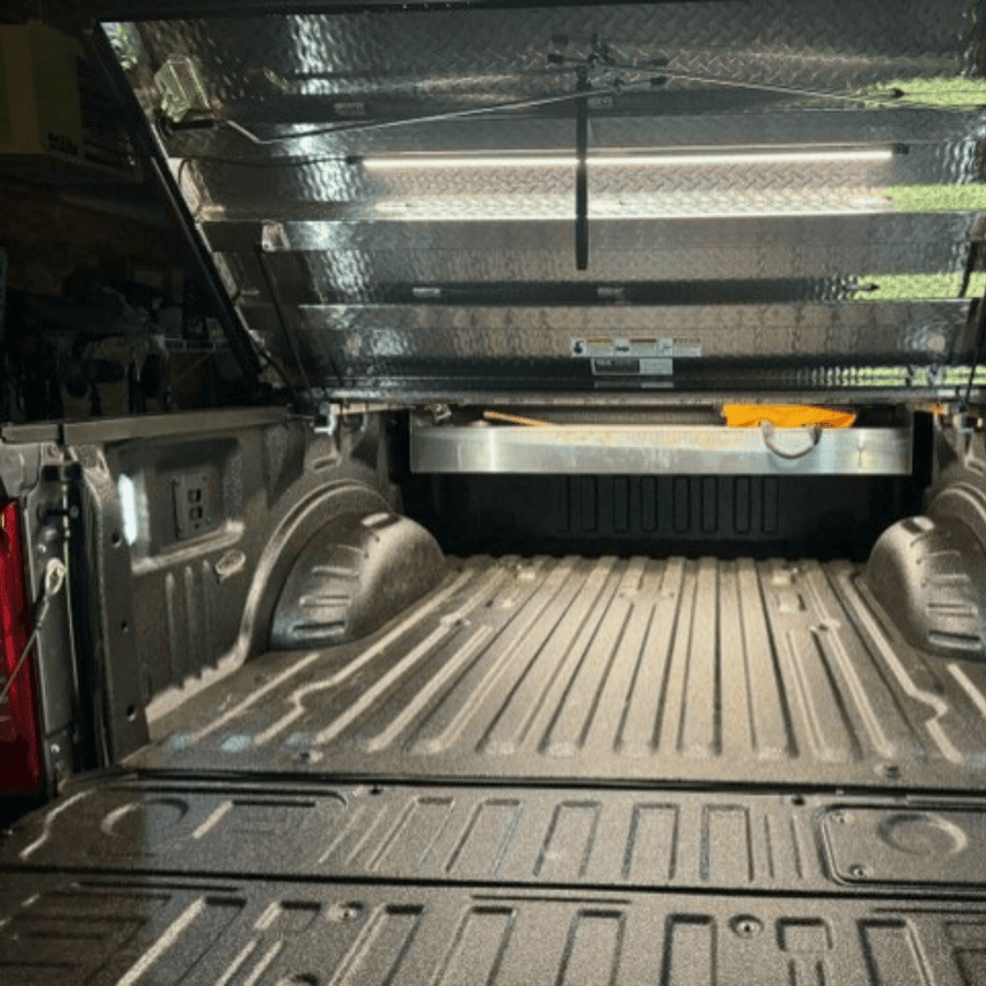 Truck bed under a bed cover lit by a Kingpin light
