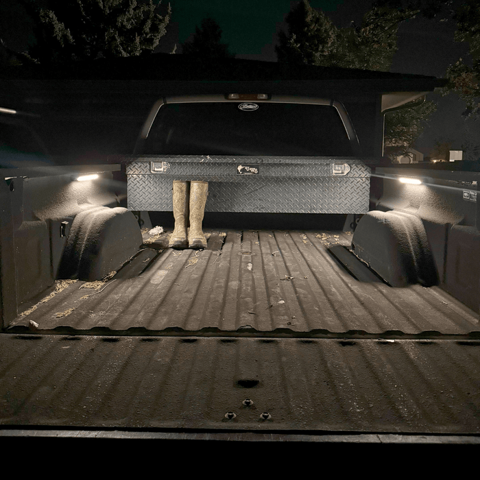 Open truck bed at night lit by two Kingpin V-Series 12" lights