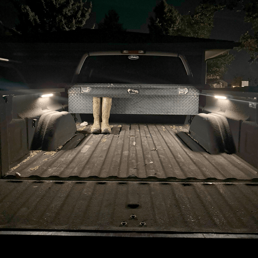 Open truck bed at night lit by two Kingpin V-Series 12" lights