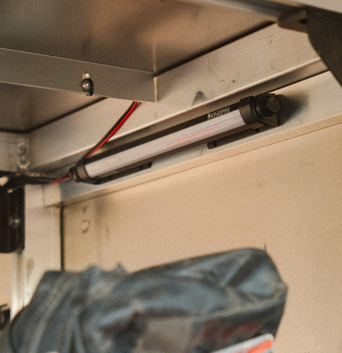 Kingpin V-Series 12" light mounted in a camper storage area