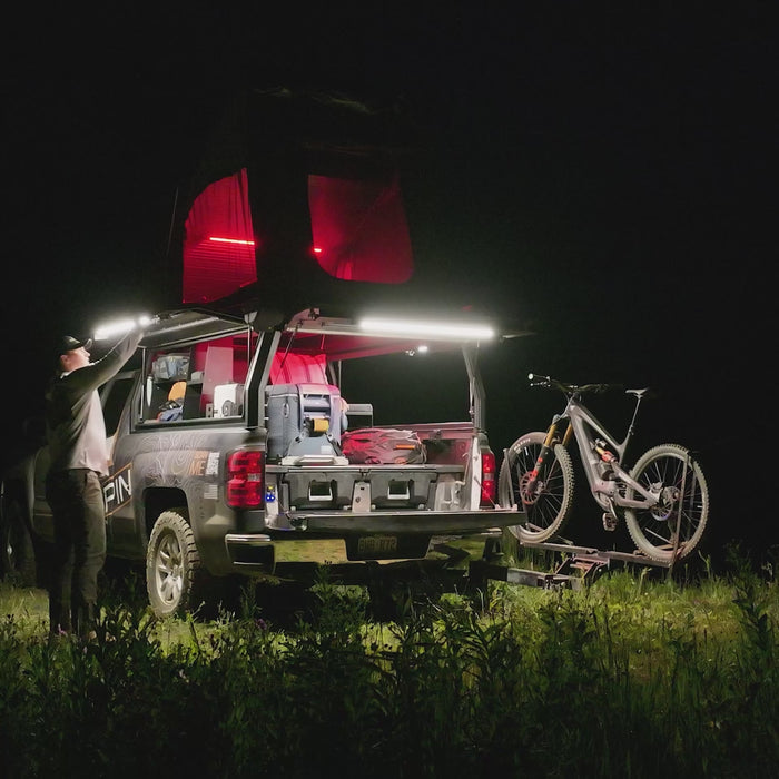 Truck with a rooftop tent and a bike at night, lit by Kingpin F-Series lights